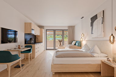 Modernes Hotelzimmer mit zwei Betten, Küchenzeile und Essbereich, große Fenster und Balkon.