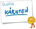 Logo mit dem Schriftzug "Qualität Kärnten" und einem goldenen Siegel.